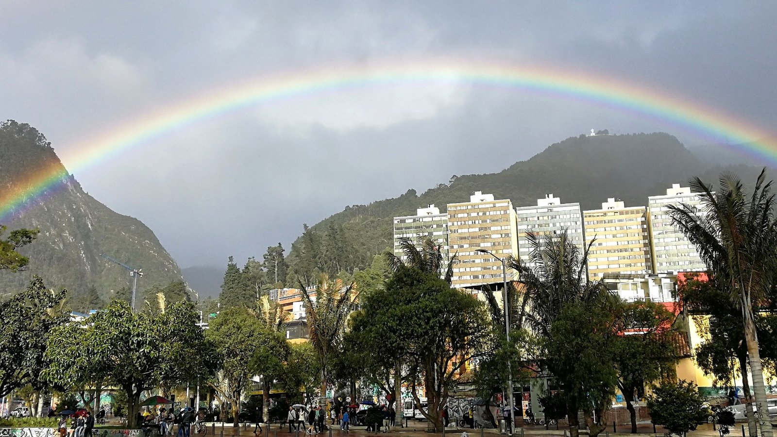 Panorama urbano y ambiental de Bogotá bajo un arcoíris